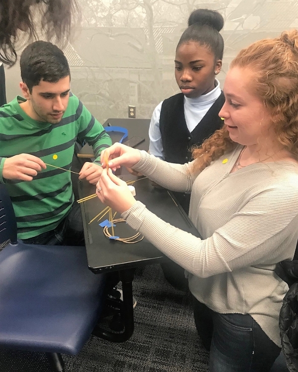 Three students building a tower during Tutor Training
