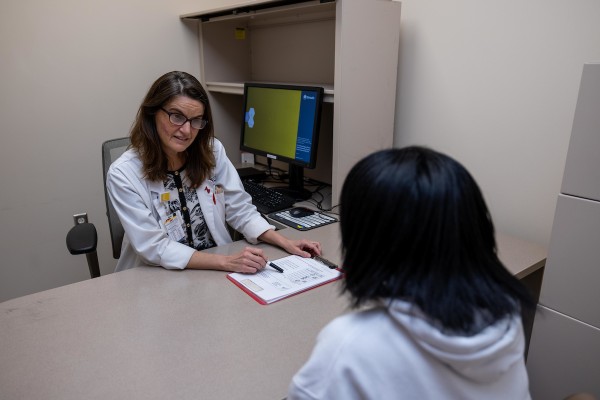 Dr. Susan Bantz meeting with a student in a small private clinic room.