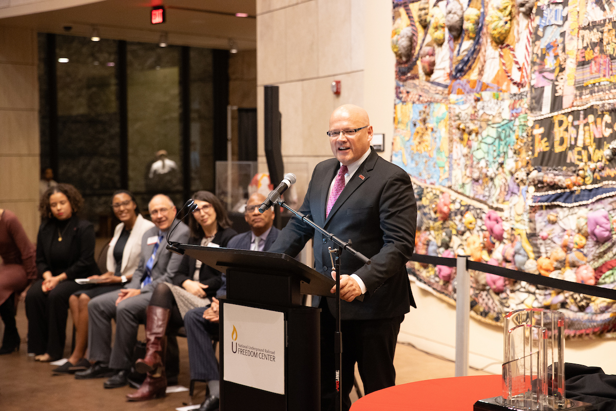 President Greg Crawford stands at the podium to introduce Wil Haygood.