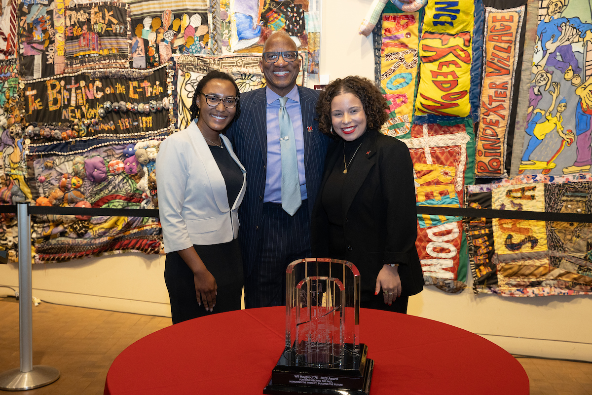 Pictured left to right are Jules Jefferson, Wil Haygood, and Nyah Smith standing behind a table with the FS64 Award on display.