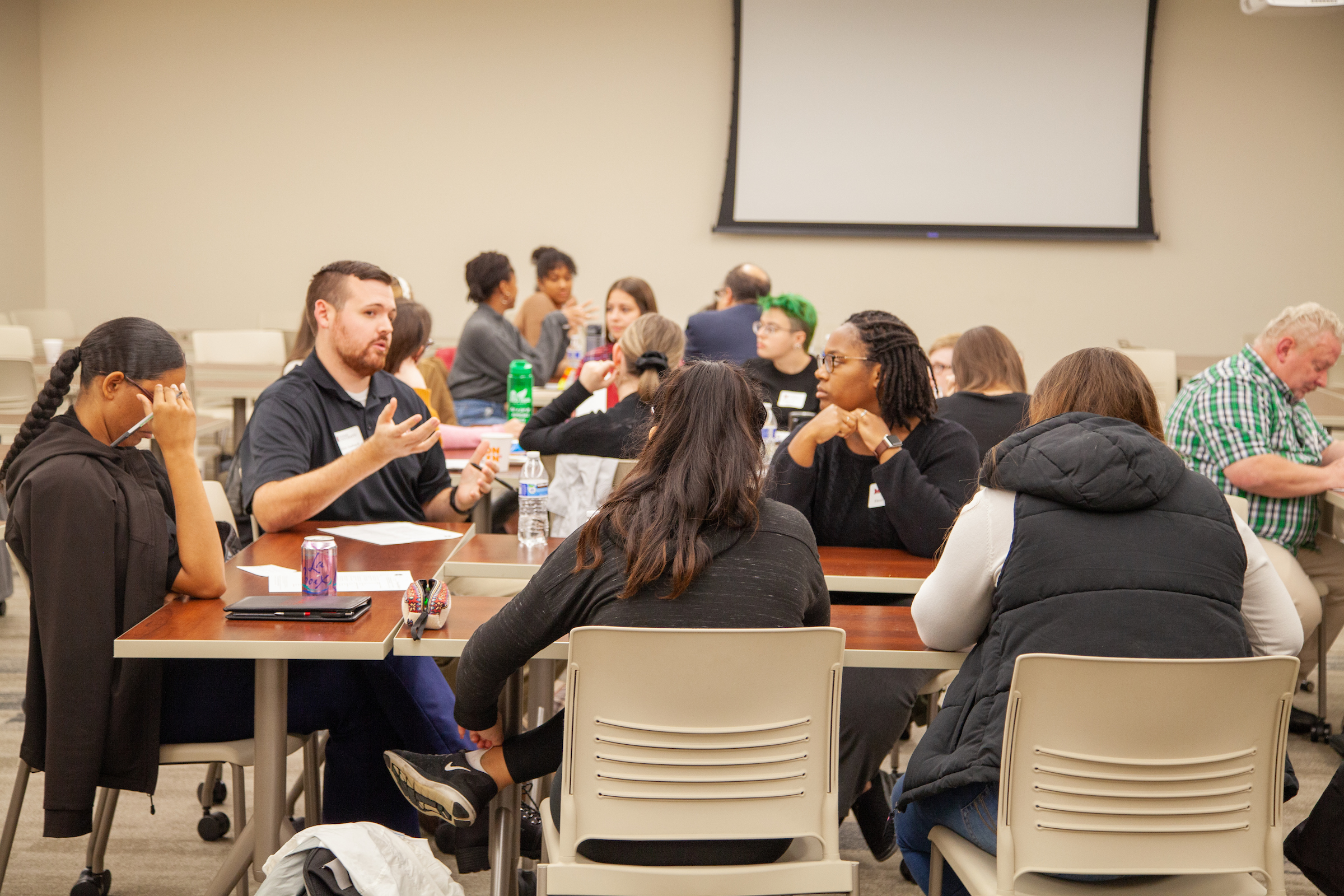 A group of staff members seated at a table in dialogue.