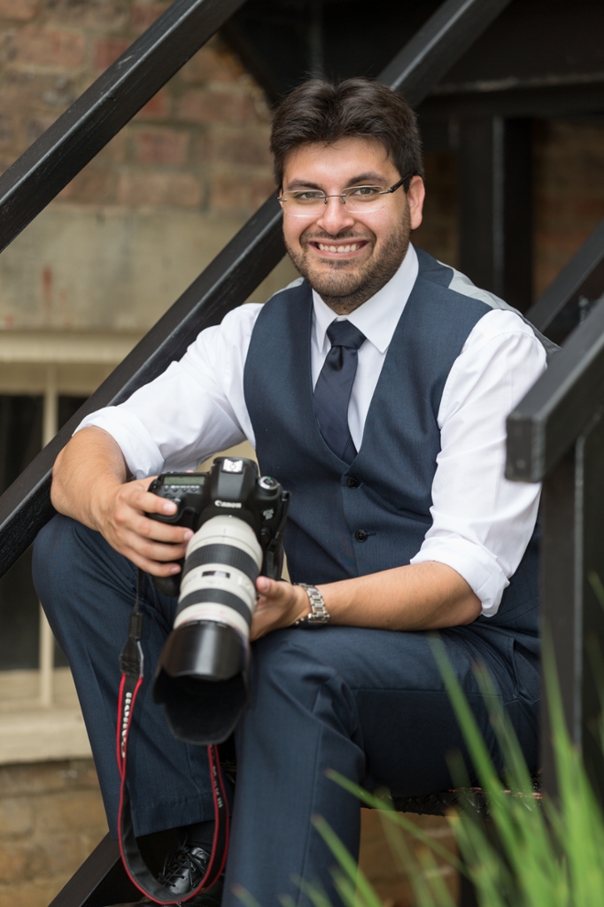 Photo of Ricardo Trevino sitting on stairs with a canon camera in hand