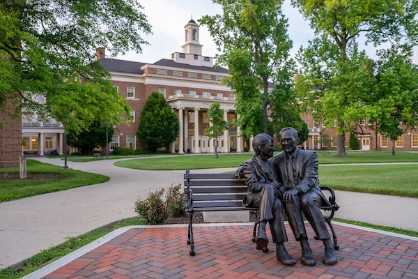 Sculpture of the Farmers sitting on a bench in front of the Farmer School of Business