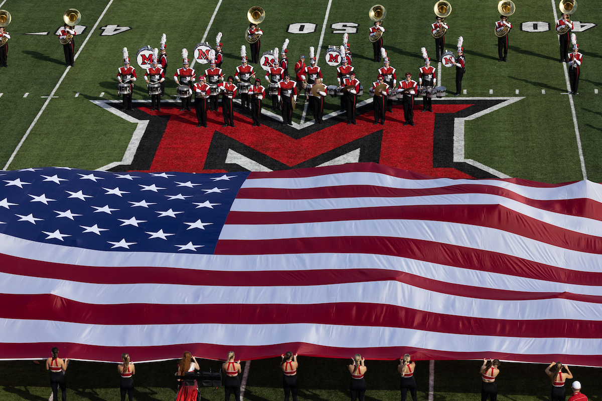 A Garrison Flag is displayed on the football field during the National Anthem.