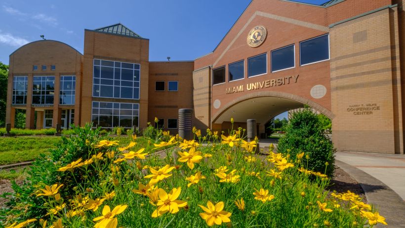 The front of the large archway entrance to the Hamilton campus on a bright sunny day