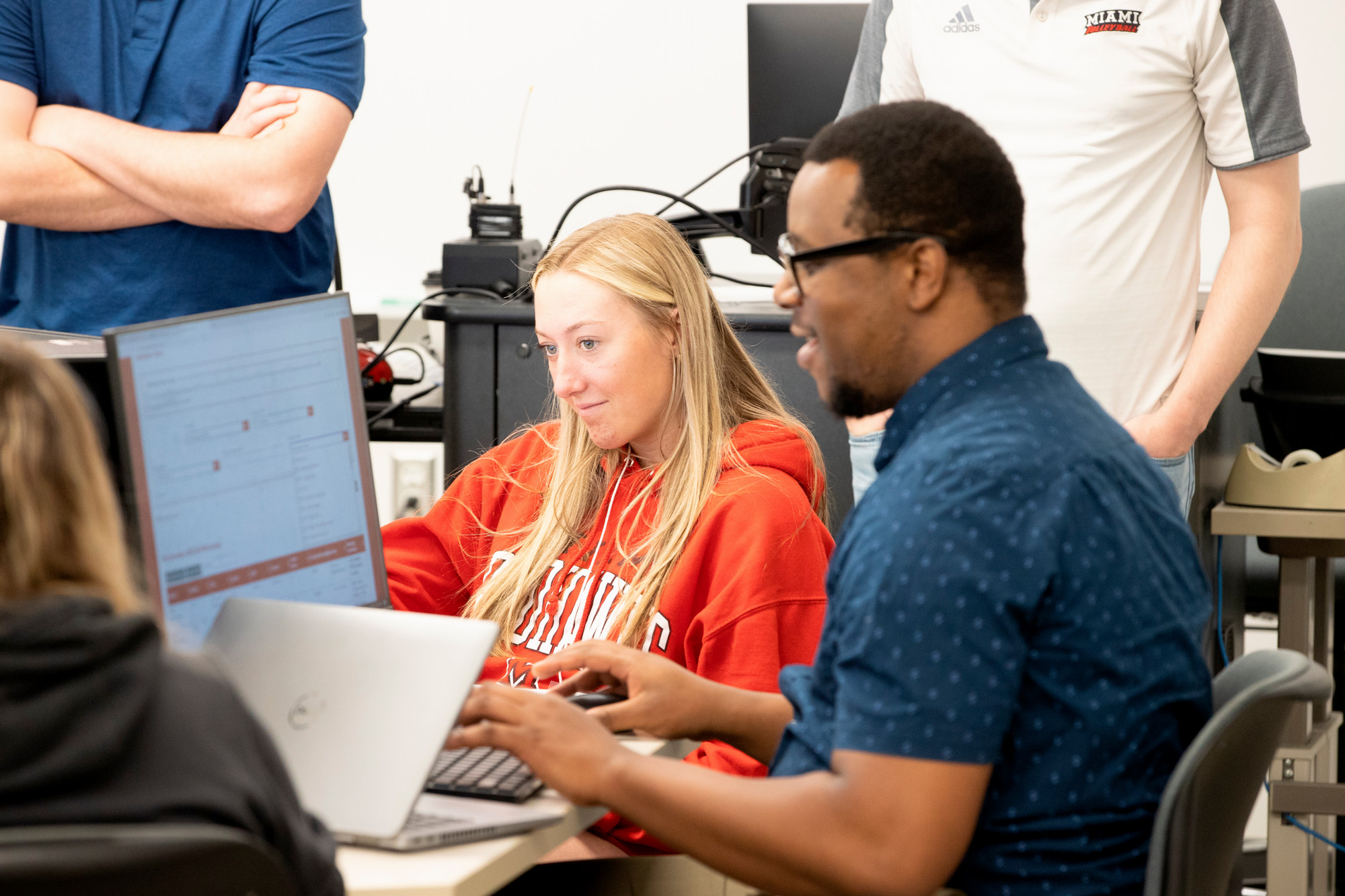 A student works on a computer with an advisor.