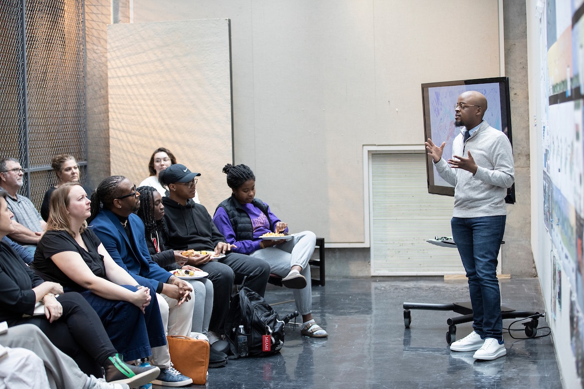A man in front of a small audience giving a presentation