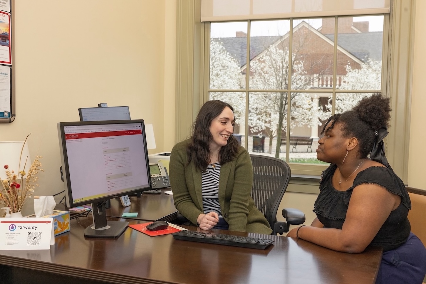 An academic advisor meeting with a student in their office.