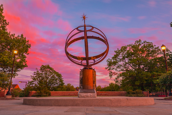 Sundial in central quad with red clouds in the background